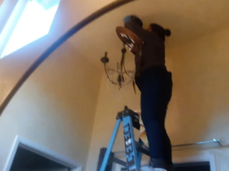 Electrician installing a chandelier in a Golden Valley residence
